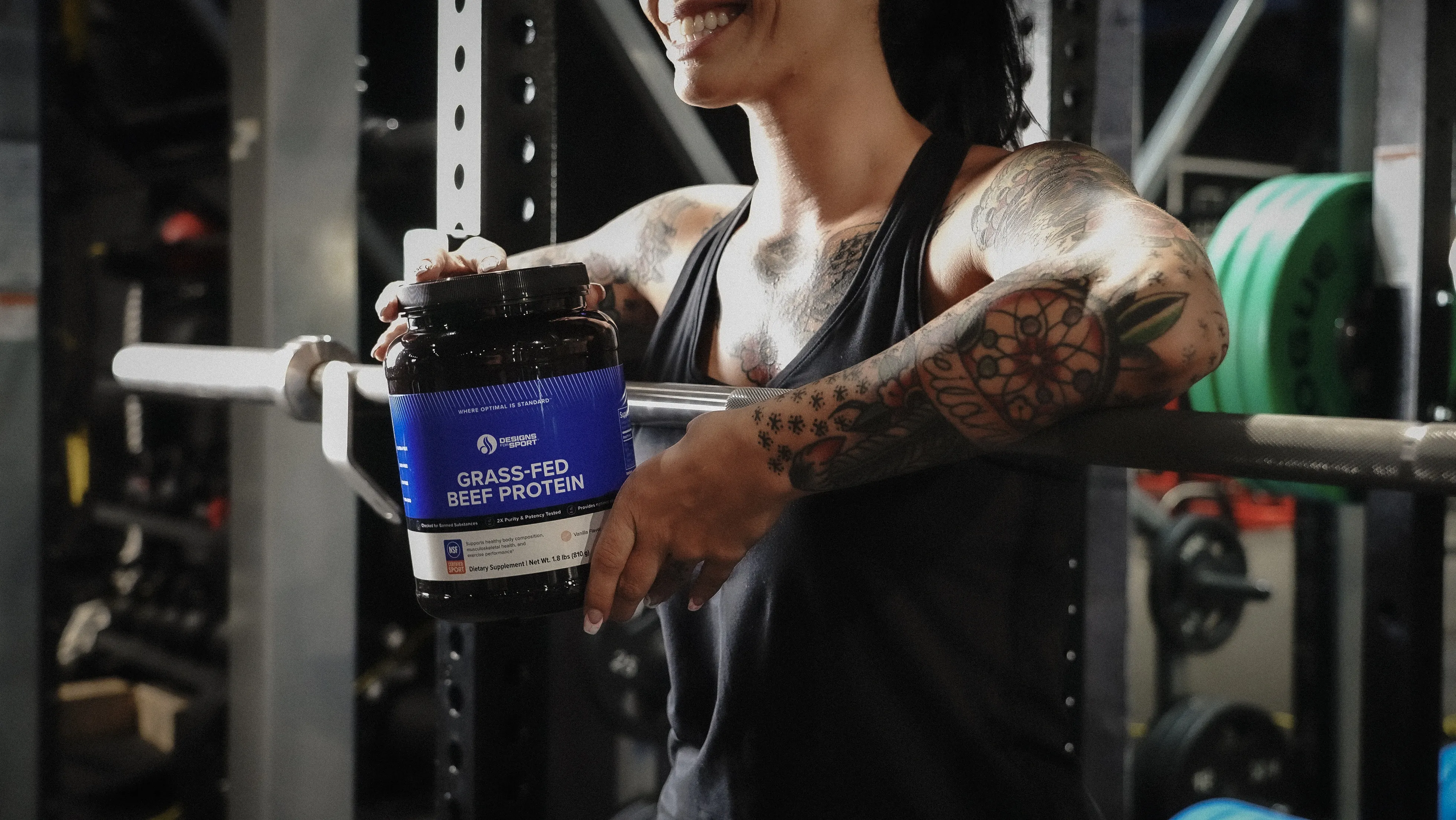 Athlete holding a grass-fed whey protein tub